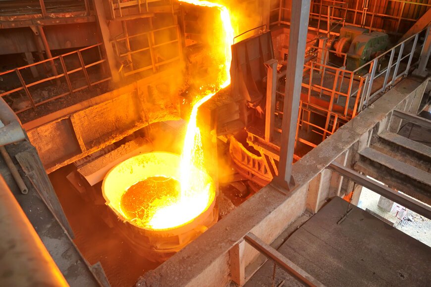 Metal being tapped out of a foundry furnace into a pouring ladle