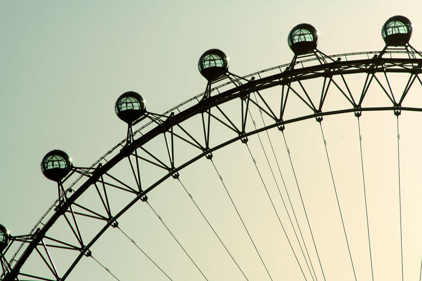 A segment of the London Eye Ferris Wheel against the sky at sunset